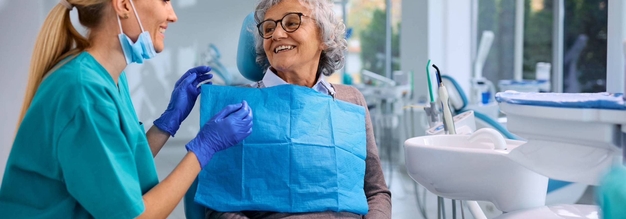 Happy,Elderly,Woman,Talking,To,Her,Orthodontist,During,Appointment,At